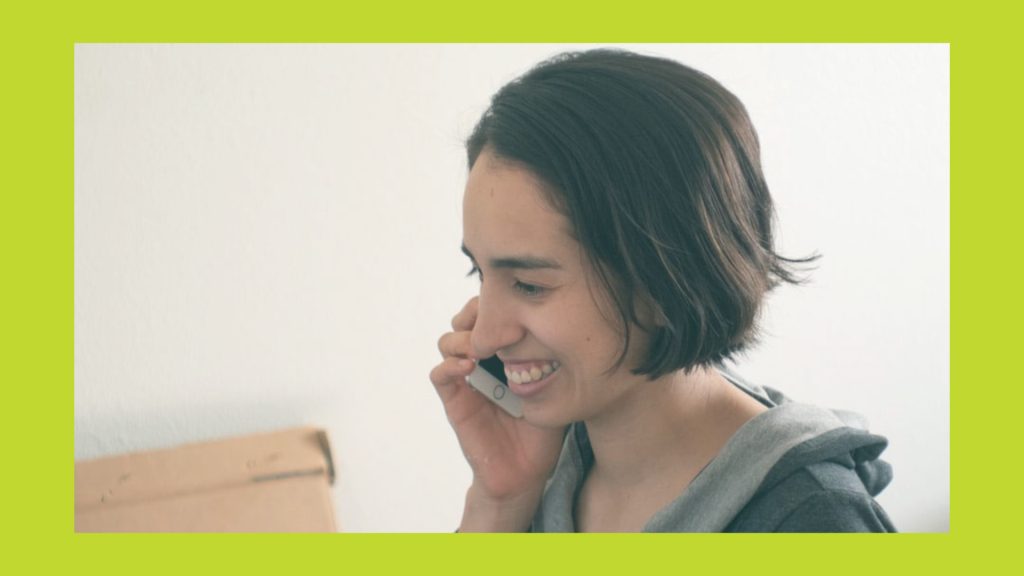 A smiling woman talks on the phone | Une femme souriante parle au téléphone