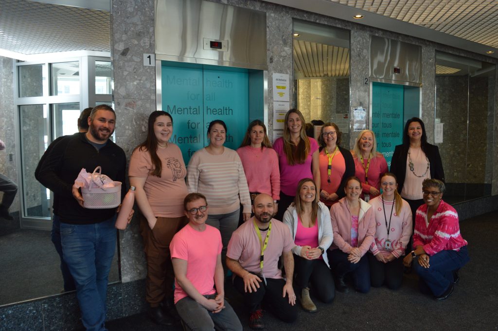 A group of CMHA Ottawa staff wears pink shirts in support of Pink Shirt Day.

Un groupe d'employés de l'ACSM Ottawa porte des chemises roses à l'occasion de la Journée des chemises roses.