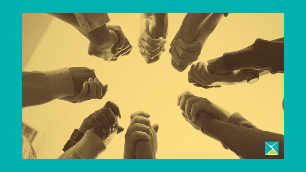 Une vue d'en bas d'un cercle de personnes se tenant par la main, signifiant la communauté.